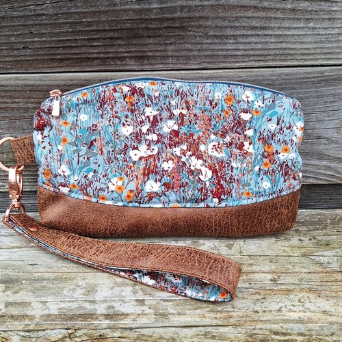 Pochette clutch pour femme avec dragonne amovible en tissu bleu pétrole avec des fleurs sauvages et faux cuir camel