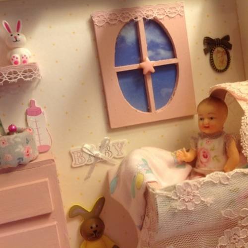 La chambre de bébé toute rose  dans une vitrine miniature 