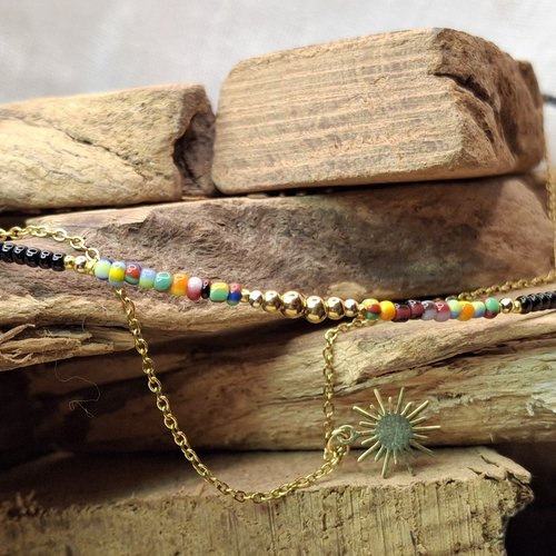 Collier double rang "solaire" en acier doré et perles colorées.