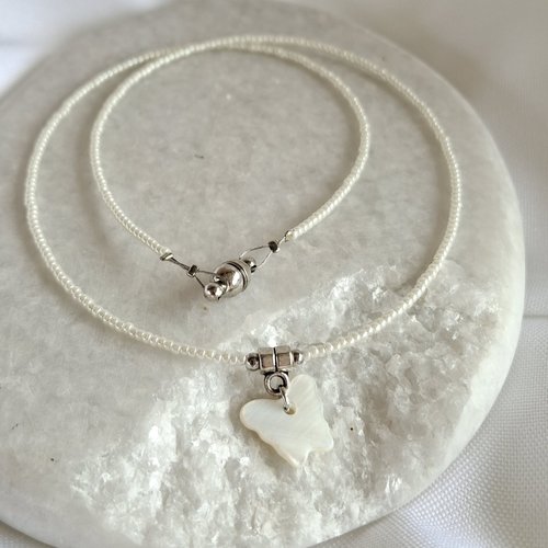 Collier ras de cou 39 cm en perles de rocaille blanches, pendentif papillon en nacre blanche, fermoir aimanté