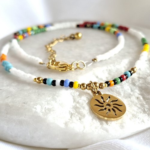 Collier blanc et perles multicolores avec médaille soleil dorée