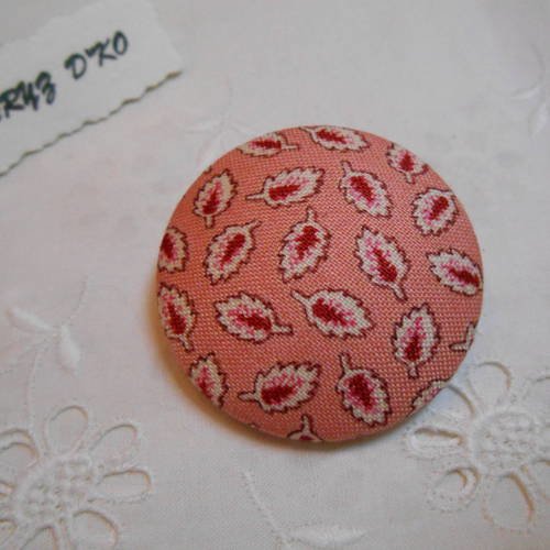 Bouton tissu 40mm recouvert d'un coton feuilles fond rose 