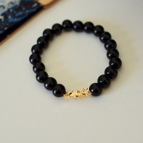 Bracelet d’onyx noir 8mn avec des petites étoiles en acier doré