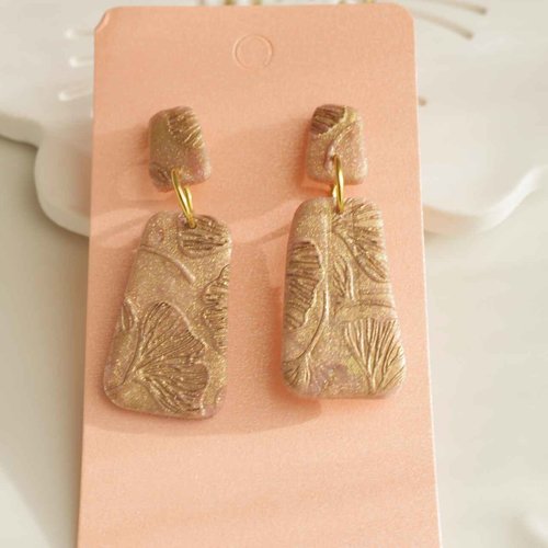Boucles d’oreilles artisanales réalisées en polymère beige rose aux reflets dorés avec des feuilles ginkgos
