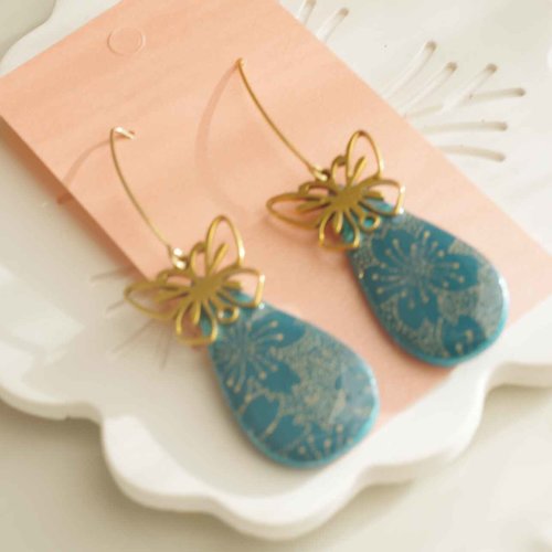 Boucles d’oreilles artisanales en polymères vert bleu avec du papier washi résiné avec un papillon en acier