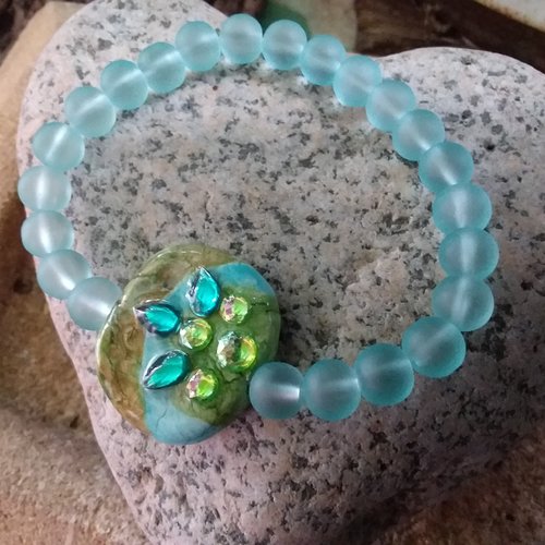 Des tons doux pour ce bracelet de perles, avec une pièce centrale en céramique, création artisanale unique