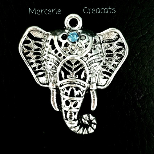 1 pendentif tête d' éléphant  métal argenté ajouré et strass bleu
