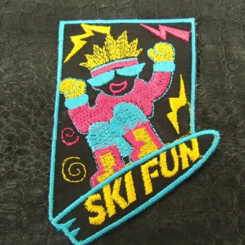 Ecusson thermocollant- motif ski fun bleu rose et jaune sur fond noir ,largeur 6 cm/ hauteur 9 cm