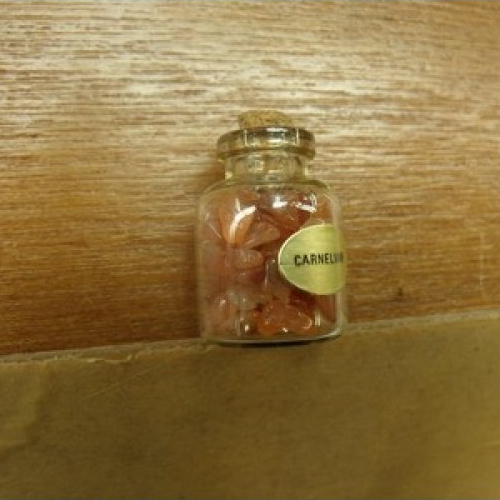 Flacon rempli de plusieurs petites pierres- carnelian ,hauteur: 3 cm / diametre: 2 cm