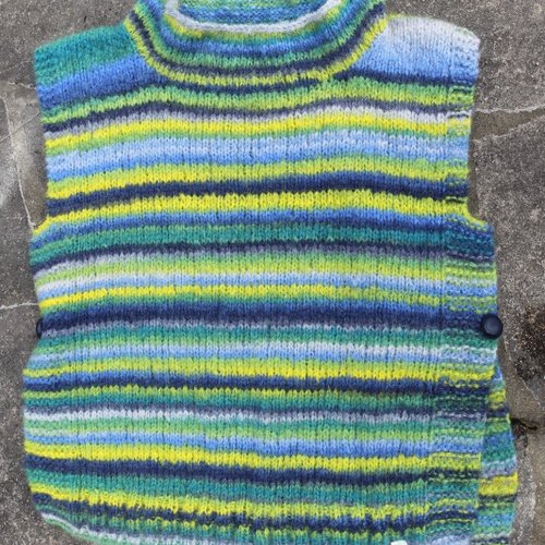 Sur pull rayé jaune, vert et bleu, alpaga et laine.