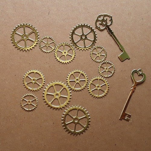 12 engrenages, roues dentées, rouages et 2 clés en papier cartonné métallisé doré 