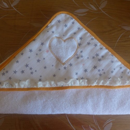 Cape de bain en éponge blanche pour le bébé. 