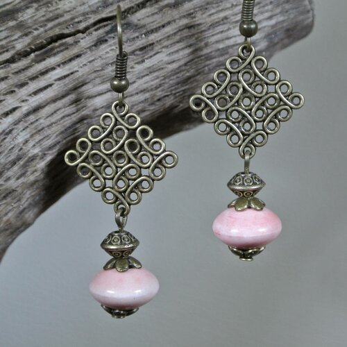 Boucles d'oreilles perle en céramique rose pâle sur un support losange effet fil enroulé couleur bronze, longueur 