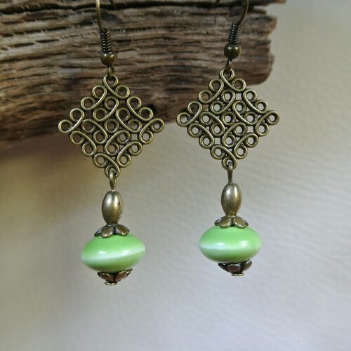 Boucles d'oreilles perle en céramique vert tendre sur un support losange effet fil enroulé couleur bronze, longueur 