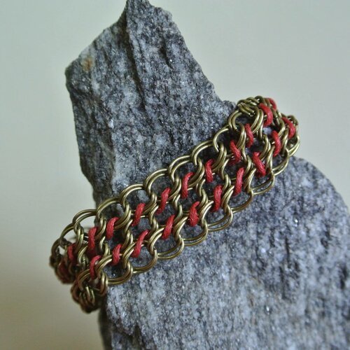 Bracelet chaîne double maille sur trois rangs couleur bronze tressés deux à deux par un cordon rouge,
