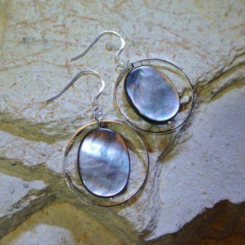 Boucles d'oreilles perle forme palet ovale en nacre grise irisée dans un fin cercle en métal argenté, crochet 