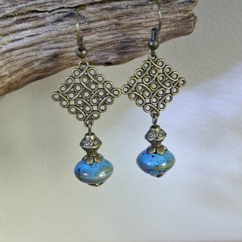 Boucles d'oreilles perle en céramique bleu tacheté sur un support losange effet fil enroulé couleur bronze, longueur