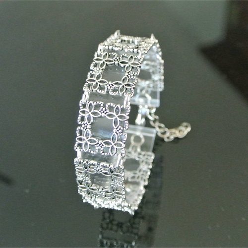 Bracelet manchette fins connecteurs cadres ajourés motif floral en métal argenté platine, fermoir mousqueton, longueur 18,5 cm extensible