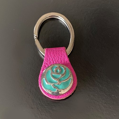Un porte-clés 6,5 cm, cuir rose vif et anneau ovale, bouton snap 20 mm décor fleur stylisée turquoise en métal argenté