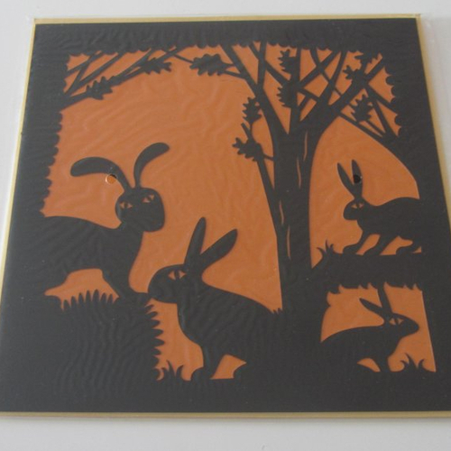 Splendide carte découpée où se révèlent quatre lapins en ombres chinoises