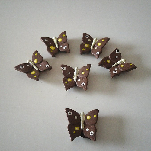 Sachet de six papillons en résine peinte avec  pastille autocollante au dos