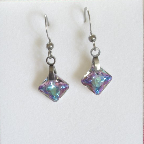 Boucles d'oreilles pendantes ornées de cristaux haut de gamme de couleur violet à reflets scintillants.