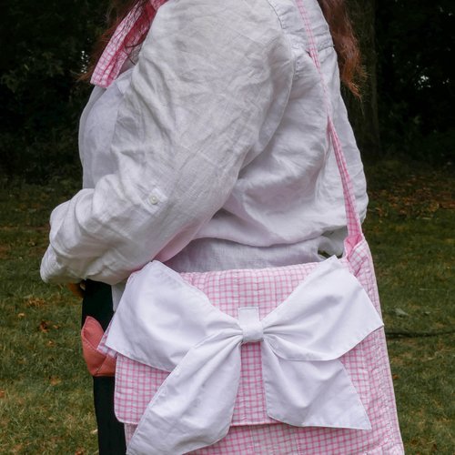 Sac bandoulière rose à carreaux avec un nœud blanc