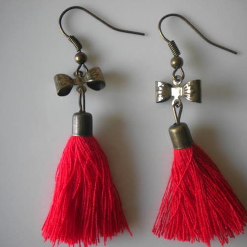 Boucles d'oreilles percées noeuds bronze pompons rouges 