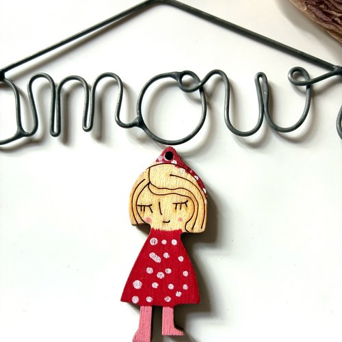 Pendentif forme petite fille yeux fermés robe à pois rouge