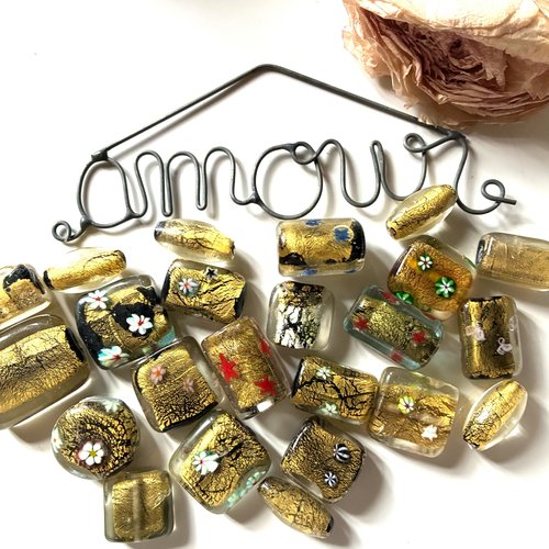 23 perles en verre en noir et doré et à motifs fleurs