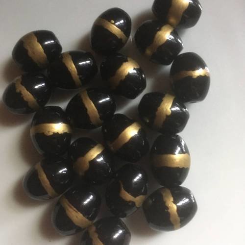 Duo de perles ovales en verre en noir cerclées en doré 