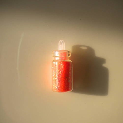 Fiole en verre 25mm avec des micro paillettes en orange 