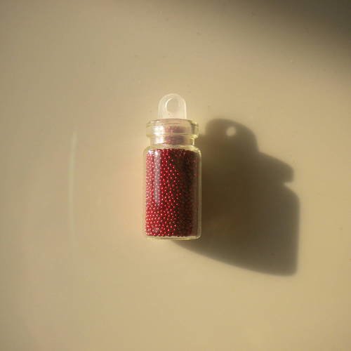 Fiole en verre 25mm avec des microbilles en rouge 