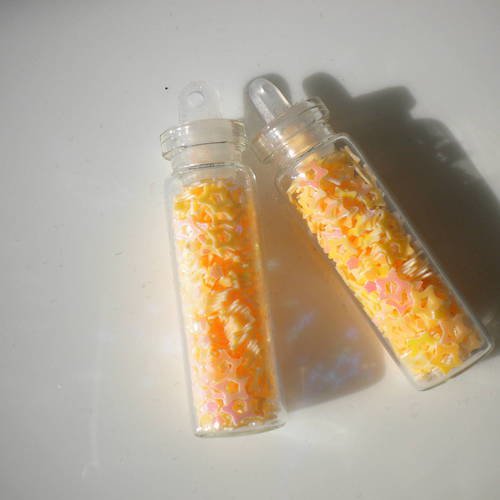 Fiole en verre 3cm avec des micropaillettes étoiles en orange pâle 