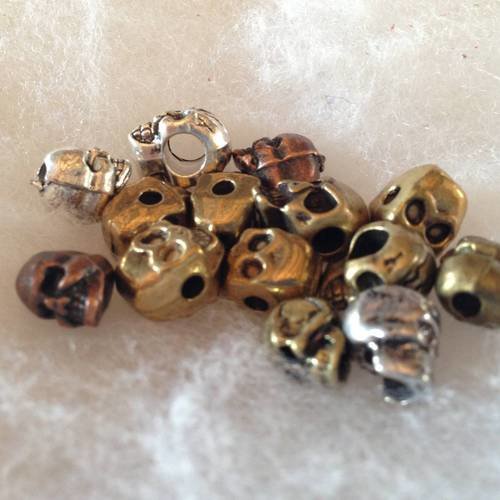 Lot de perles métal argenté, cuivre et bronze tête de mort x14 