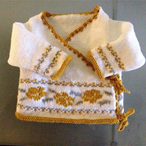 Cache coeur bébé tricoté main blanc brodé de fleurs moutarde et liseré dentelle au crochet