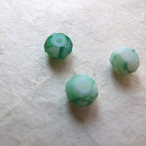 Perles à facettes en verre vert clair marbrées vert foncé sur fond blanc