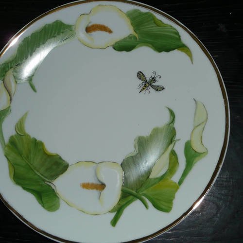 Assiette ou plat rond en porcelaine peinte main décorée d'arums et d'un insecte. filet or brillant