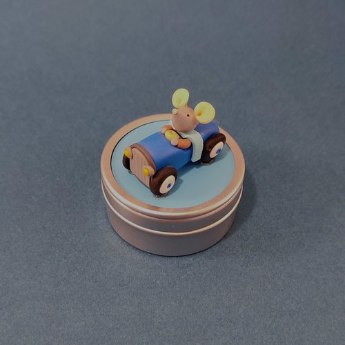 Boîte à dents de lait souris dans sa voiture à pédales