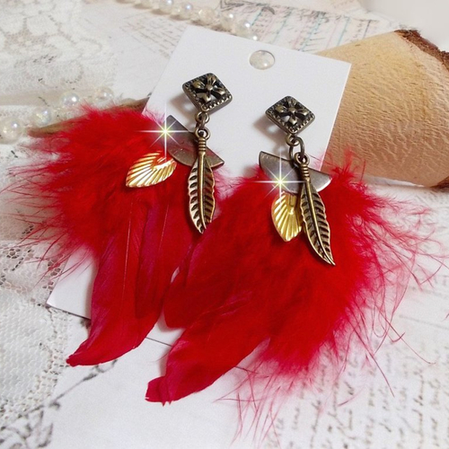 Boucles d’oreilles sagesse amérindiennes aux plumes rouges, breloques dorées, plumes et clous d’oreilles bronze.