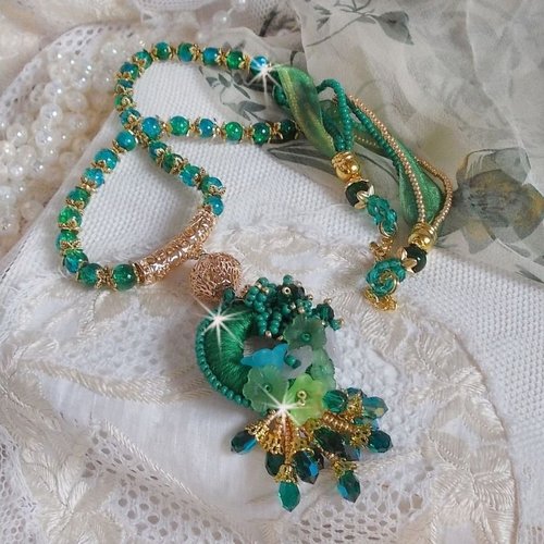 Collier green iris brodé avec du coton dmc vert sur un anneau avec fleurs, cristaux, perles, rocailles et ruban, un style contemporain