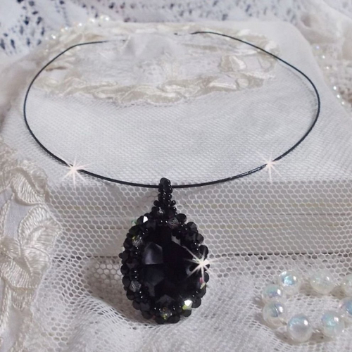 Pendentif mirano de style baroque avec un cabochon ovale en cristal cerclé de rocailles et toupies aux couleurs noires et argentées.