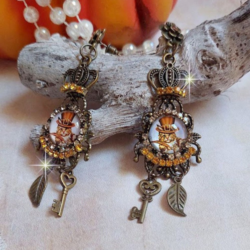 Boucles d’oreilles chatibo steampunk montées avec cabochons représentant un chat, cristaux et breloques, un look fantaisiste !