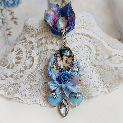 Pendentif infiniment bleuté créé avec fleurs synthétiques, résine, cabochon verre, ruban velours et perles cristal swarovski