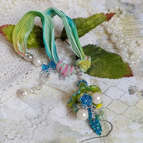 Collier regard scintillant créé avec fleurs acryliques, ruban de soie, chaîne en argent et perles cristal swarovski