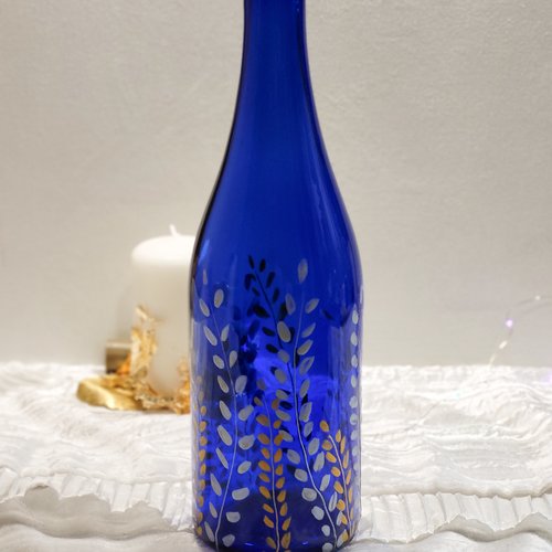 Bouteille en verre bleu peinte d’un motif végétal or et argent  photophore pour noël  pendaison de crémaillère