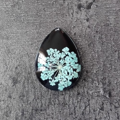 Cabochon goutte en verre avec fleurs séchées bleu clair sur fond noir - 18x25mm 