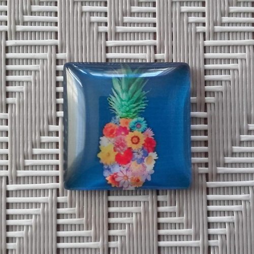 Cabochon en verre carré 20mm x 20mm. ananas avec fleurs multicolores sur fond bleu.