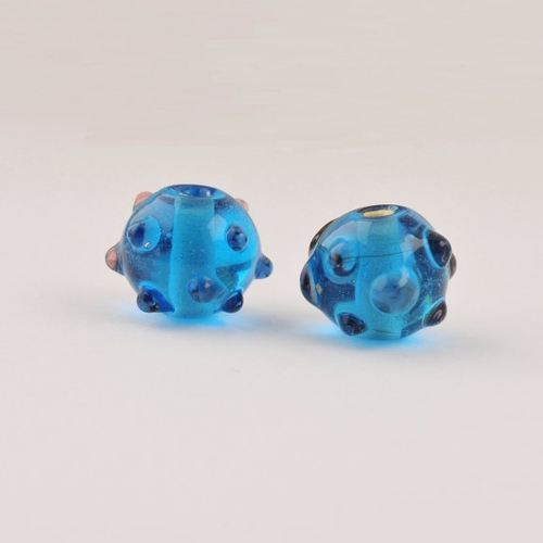 2 perles en verre bleu à picots