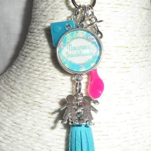 Porte clés / bijou de sacs cabochon " nounou inoubliable " avec breloques et pompon bleu. 